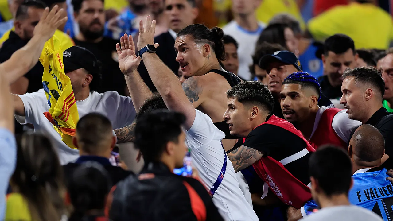 Jugadores de fútbol de Uruguay chocan con aficionados colombianos después del partido de la Copa América.